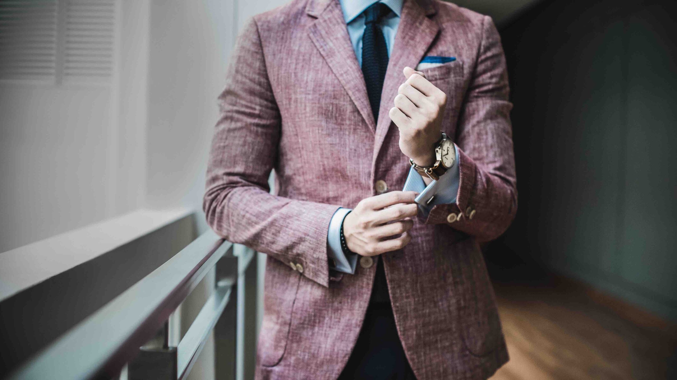 Modern Man making a personal style statement with a trendy tea pink coat and a watch